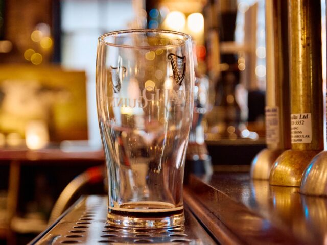 An empty Guinness glass, seen behind the bar inside The Old Ivy House public house in Cler