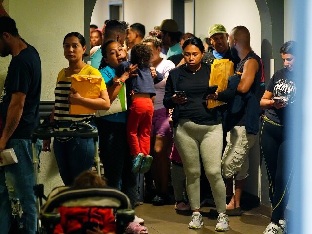 People queue up to attend an orientation session for recent immigrants, Monday, May 20, 20