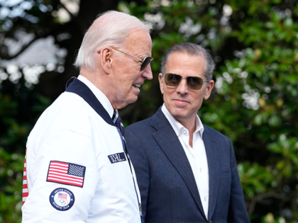 President Joe Biden, wearing a Team USA jacket and walking with his son Hunter Biden, head