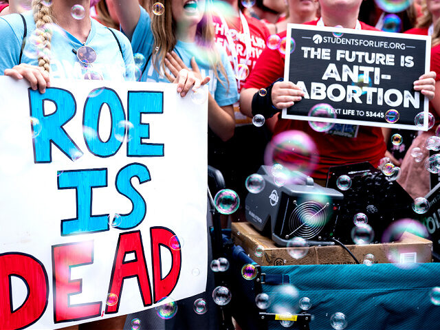 Anit-abortion activists hold signs outside the US Supreme Court after overturning of Roe V