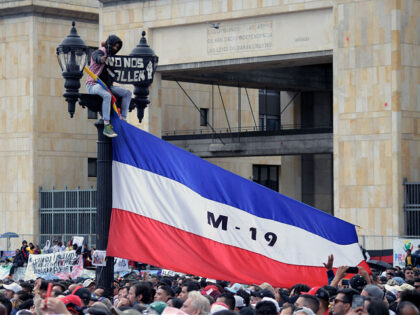 A man hangs a flag of the M-19 (Movimiento 19 de Abril) -a former guerrilla group which tu