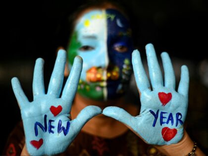 A student poses with her painted face and hands, ahead of New Year celebrations at a colle