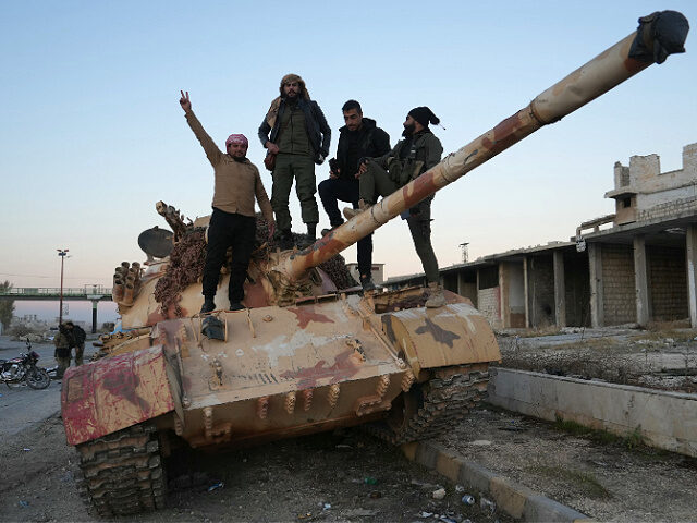 TOPSHOT - Anti-government fighters pose for a picture on a tank on the road leading to Maa