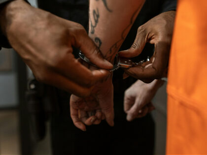 Close-Up Shot of an Officer Putting Handcuffs on a Prisoner