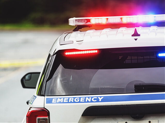 Police block a road on an emergency scene.