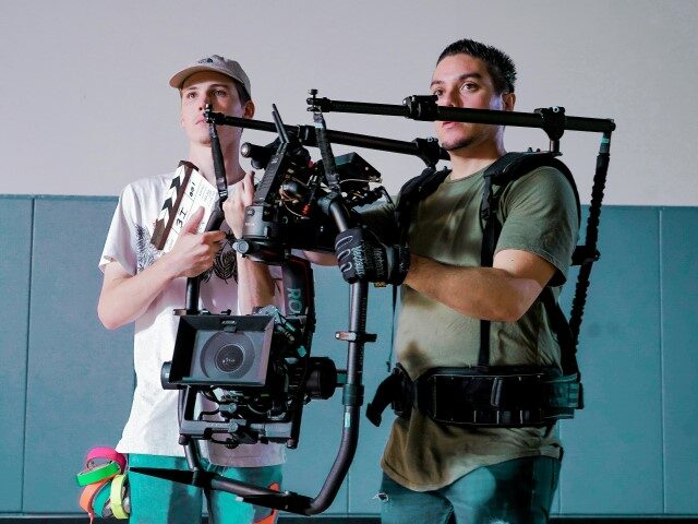 Video production employees holding a camera.