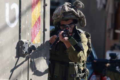 An Israeli soldier takes aim outside the Turkish hospital in Tubas in the occupied West Ba