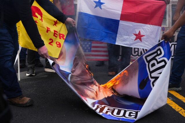 Demonstrators burn Donald Trump's image following his threat to demand control of the Pana