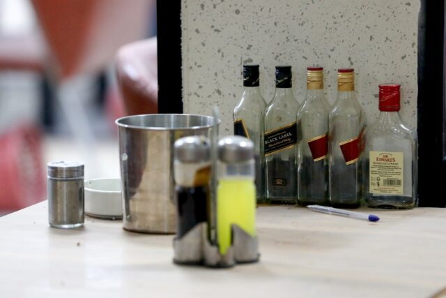 Empty whisky bottles on the bar of a Baghdad club ordered closed by Iraqi security forces