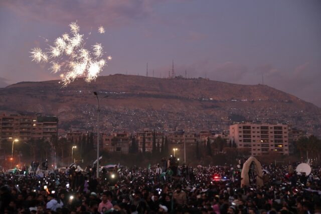 Fireworks errupt as Syrians gather to celebrate the ousting of president Bashar al-Assad a