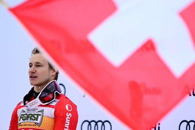 Marco Odermatt stands on the top step of the podium after winning the Alta Badia men's gia