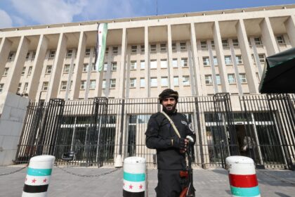 A member of the Syrian security forces stands guard outside the central bank headquarters