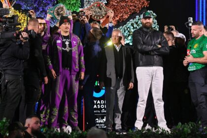 Oleksandr Usyk and Tyson Fury stand on stage during the official weigh-in