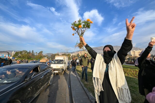 People at Umayyad Square in Damascus celebrate the end of Syrian president Bashar al-Assad