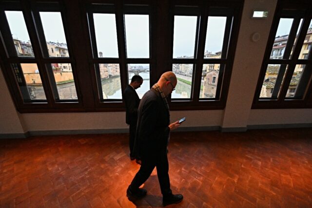 People walk in the Vasari Corridor gallery, in the center of Florence