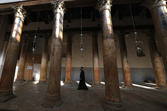 A priest walks in the virtually empty Church of the Nativity in the biblical city of Bethl