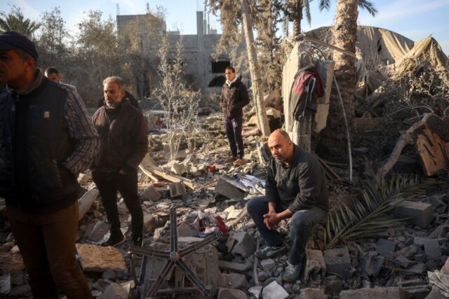 A relative of Abu Samra family looks on as Palestinians search for survivors after a strik