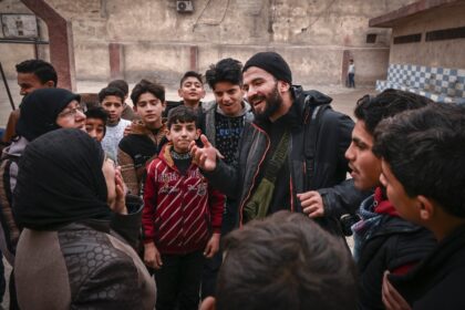 Syrian AFP photographer Sameer al-Doumy meets his neighbours after returning to his old sc