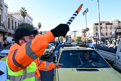 The volunteer traffic officers wear orange vests labelled 'Police'