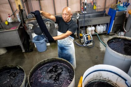 Yoshiharu Okamoto demonstrates the hand-dyed fabrics process at the Momotaro Jeans factory