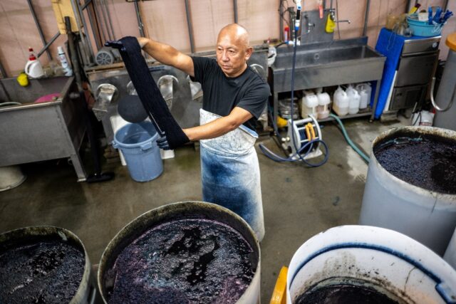 Yoshiharu Okamoto demonstrates the hand-dyed fabrics process at the Momotaro Jeans factory