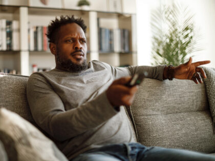 Angry man watching tv at home