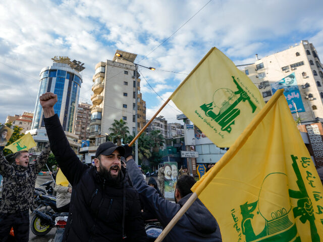 Residents celebrate carrying Hezbollah's flags in Dahiyeh, Beirut, Lebanon, following a ce