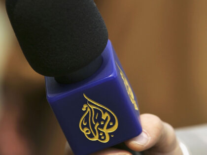 A reporter from the Arabic television channel Al-Jazeera holds a microphone during an inte