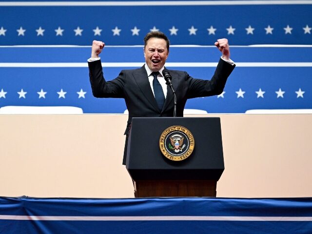 Elon Musk celebrates at a podium