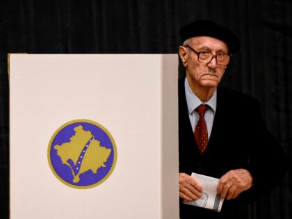 A Kosovo Albanian man prepares to cast his ballot to vote for the parliamentary election a