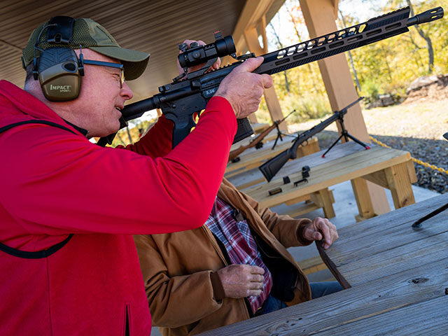 A Range Officer tests a weapon as members of the public shoot a variety of rifles and othe