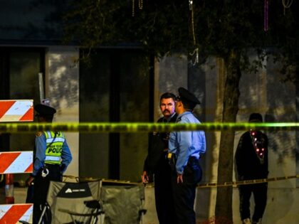 Police officers collect evidence at the scene of a shooting that occured during the Krewe