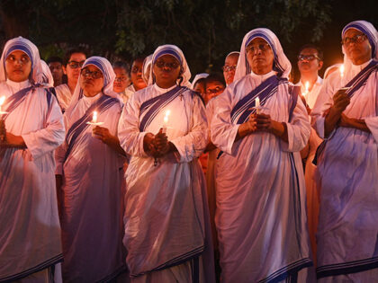 Indian Christian nuns are holding candles during a candlelight vigil outside a church to m