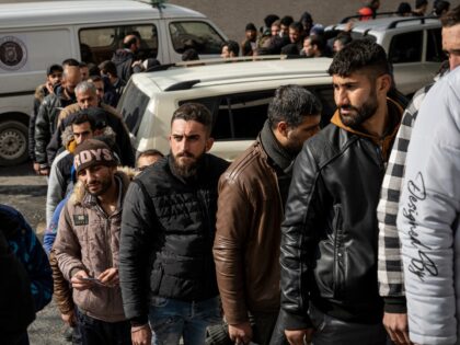 A crowd of men waits outside a police station in Damascus, Syria, on December 31, 2024. Th