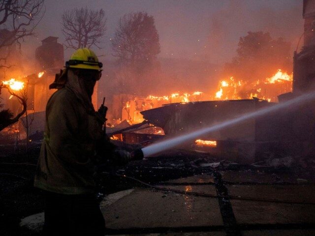 GettyImages-2192359141 A firefighter battles the blaze on El Medio Avenue during the Palisades Fire in the Pacifi
