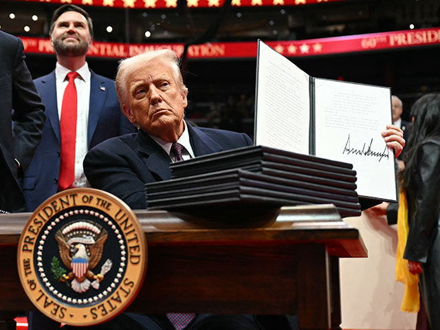 US President Donald Trump holds an executive order he just signed during the inaugural par