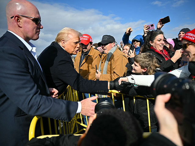 US President Donald Trump greets supporters upon arrival at Asheville Regional Airport in