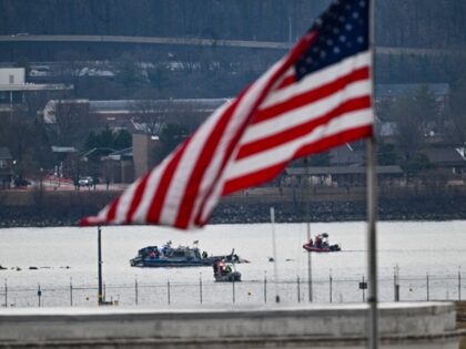 FAA - A police boat can be seen next to some mangled remains of the airplane that collided