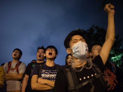 Pro-democracy protesters shout slogans during a standoff with police outside the central g