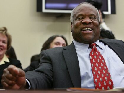 WASHINGTON - MARCH 08: U.S. Supreme Court Justices Clarence Thomas laughs at a joke about