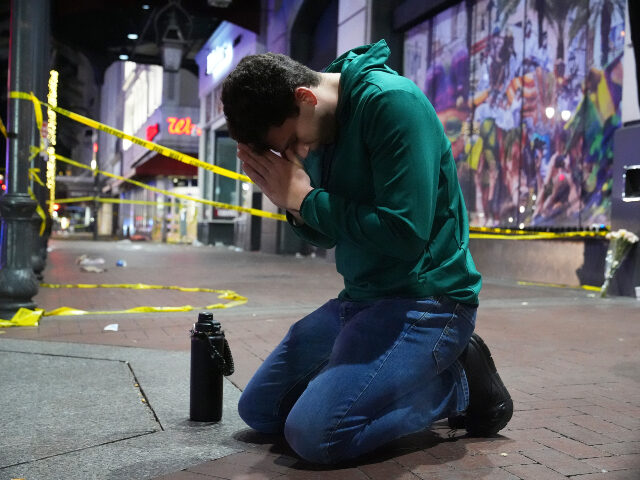 Matthias Hauswirth of New Orleans prays on the street near the scene where a vehicle drove