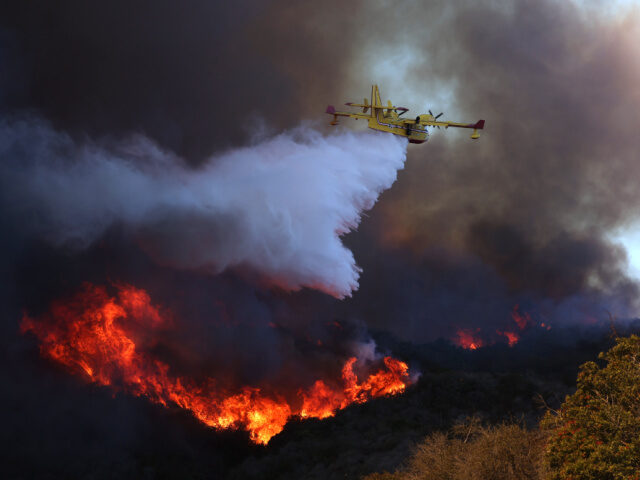 A firefighting plane makes a drop on the Palisades fire in Pacific Palisades on Tuesday, J