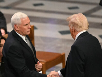 Former US Vice President Al Gore (L) watches as former Vice President Mike Pence (C) shake