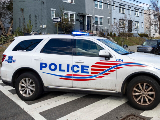 A police car blocks off a street near where a person has barricaded himself during a stand