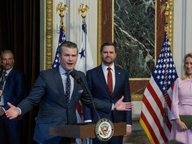 Pete Hegseth speaks his wife Jennifer Rauchet, right, listens after Hegseth is sworn in as