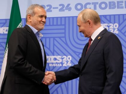 Russian President Vladimir Putin, right, and Iranian President Masoud Pezeshkian shake han