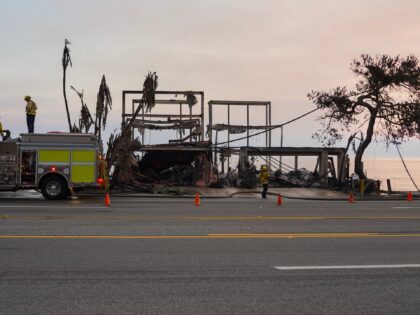 Firefighters work near houses burned down in the Palisades Fire along the Pacific Coast Hi