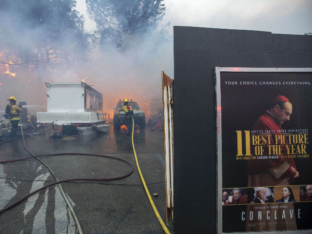 Firefighters battle a fire as a trailer burns on Sunset Blvd. during the Palisades Fire i