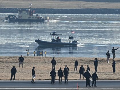 People, including law enforcement members, are seen on a runway at Ronald Reagan Washingto