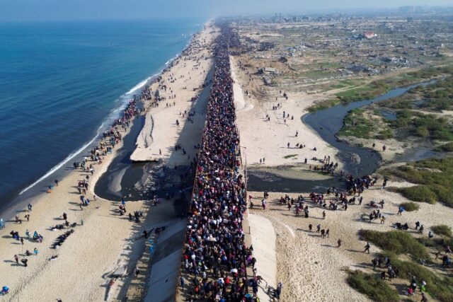 Displaced Gazans walk north along the coast after Israel reopened access to the territory'